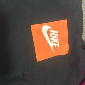 selling nike hoodie size small black with orange title with one tiny hole in it